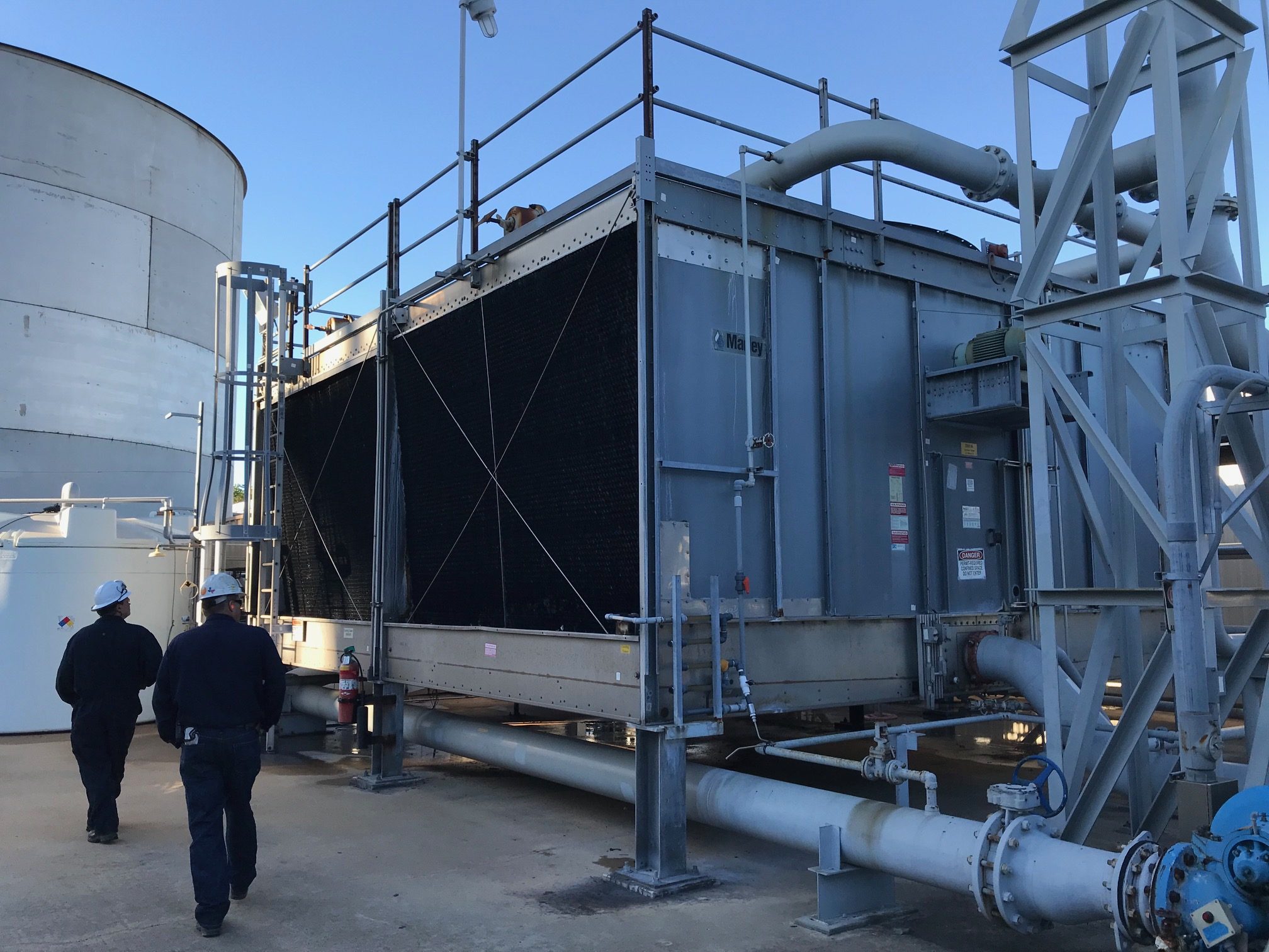A factory-assembled steel package cooling tower with cable cross-bracing, carrying a Marley badge on the casing.